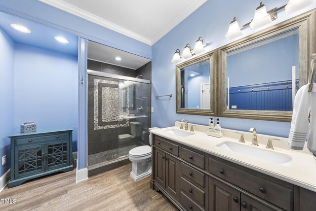 bathroom with a sink, wood finished floors, a stall shower, and toilet