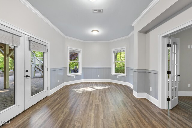 empty room featuring visible vents, plenty of natural light, french doors, and wood finished floors