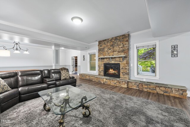 living room featuring ornamental molding, a fireplace, wood finished floors, and visible vents