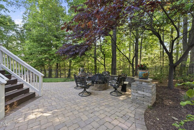 view of patio / terrace with a fenced backyard, an outdoor fire pit, and stairway