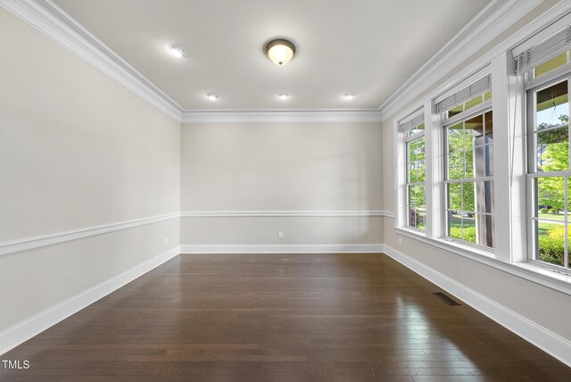 unfurnished room with visible vents, ornamental molding, dark wood finished floors, and plenty of natural light