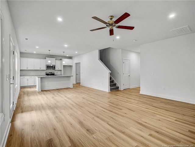 114 Kingwood Dr, Lillington, NC 27546 - unfurnished living room with visible vents, a ceiling fan, light wood-style floors, stairway, and recessed lighting