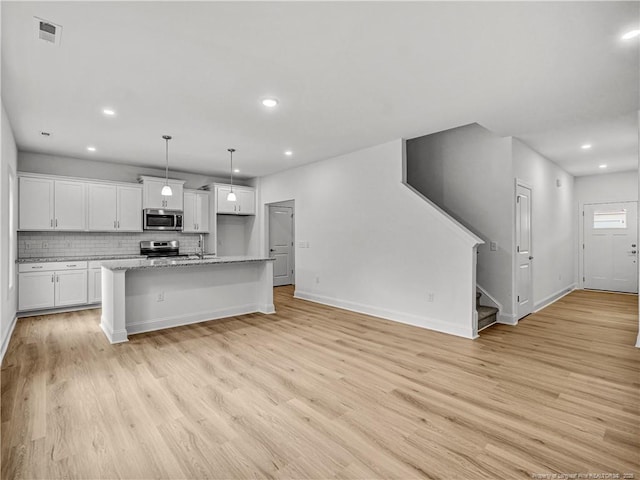 114 Kingwood Dr, Lillington, NC 27546 - kitchen featuring light wood-style floors, visible vents, white cabinetry, and appliances with stainless steel finishes
