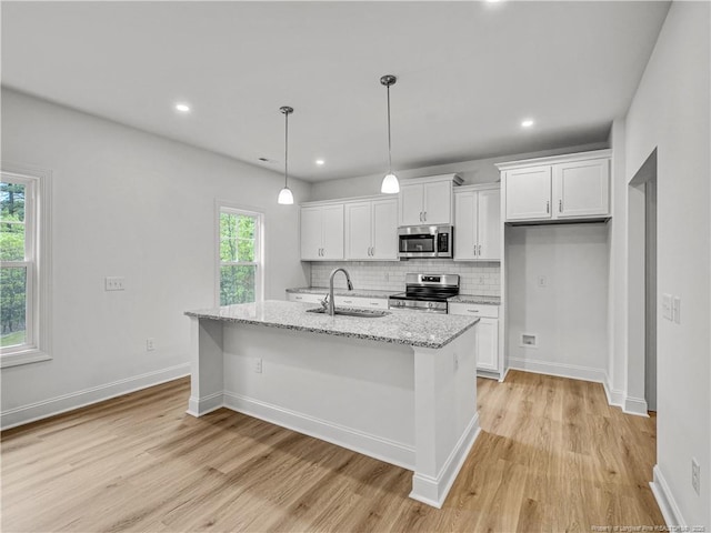 114 Kingwood Dr, Lillington, NC 27546 - kitchen featuring stainless steel appliances, light wood finished floors, white cabinets, and a sink