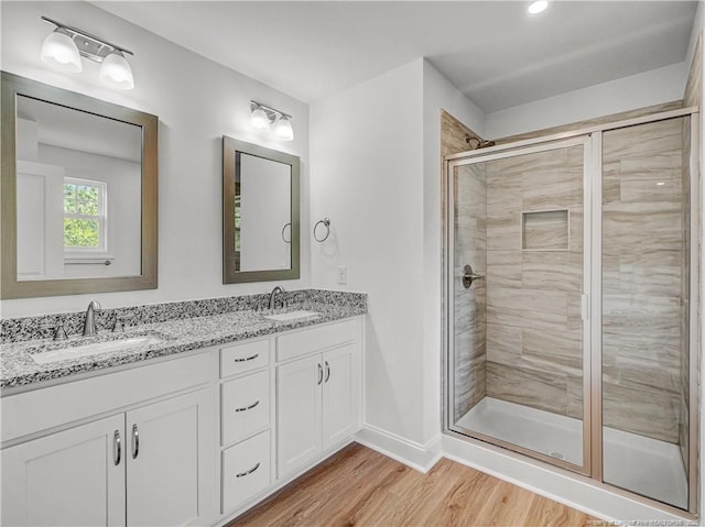 114 Kingwood Dr, Lillington, NC 27546 - full bathroom with a sink, double vanity, a stall shower, and wood finished floors