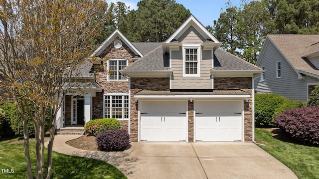 view of front facade with a front yard, a shingled roof, stone siding, a garage, and concrete driveway
