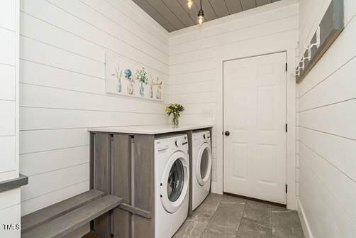 clothes washing area featuring washing machine and dryer, laundry area, and wood ceiling