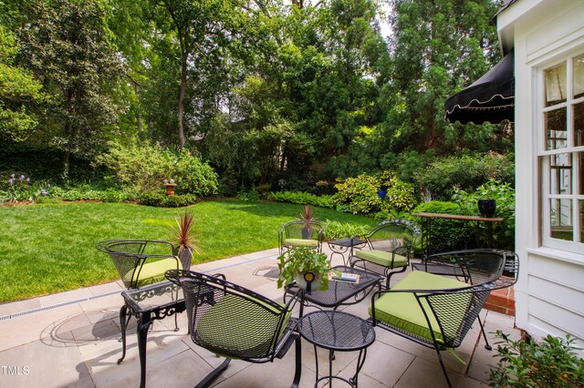 view of patio with outdoor dining space and view of scattered trees