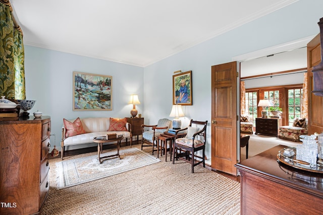 living area featuring light wood-style floors and crown molding