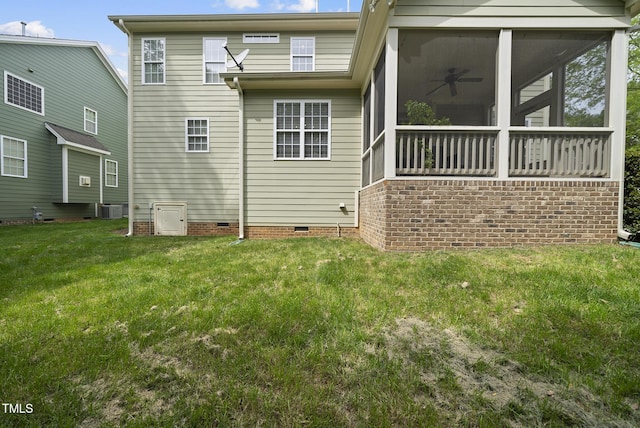 rear view of property featuring central AC, crawl space, ceiling fan, a lawn, and a sunroom