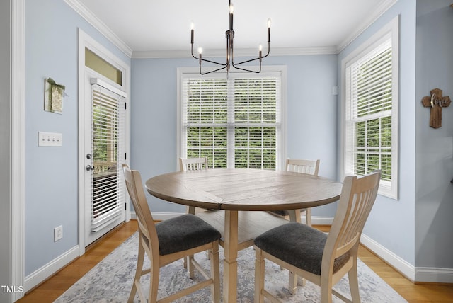 dining room featuring light wood-style floors, plenty of natural light, baseboards, and a notable chandelier