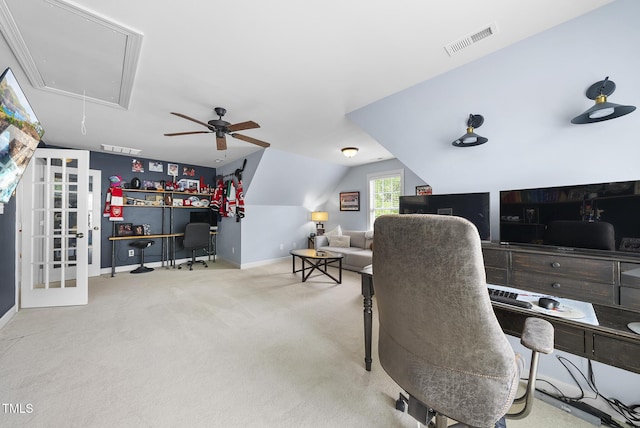 carpeted office with attic access, visible vents, baseboards, lofted ceiling, and a ceiling fan
