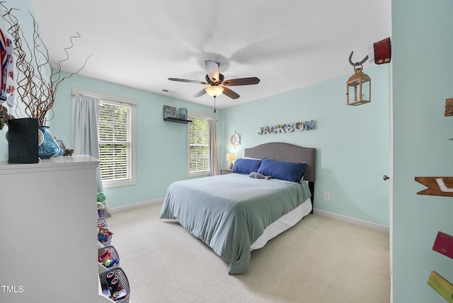 bedroom featuring baseboards, visible vents, a ceiling fan, and light colored carpet