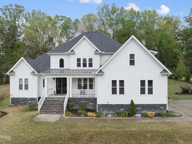 6024 Lunenburg Dr, Raleigh, NC 27603 - view of front of home featuring a front lawn, roof with shingles, a porch, and board and batten siding