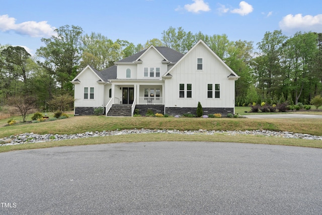 6024 Lunenburg Dr, Raleigh, NC 27603 - view of front of house with stairs, a front lawn, board and batten siding, a porch, and roof with shingles