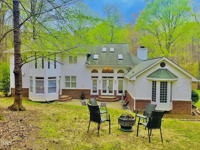 6212 Trevor Ct, Raleigh, NC 27613 - rear view of property featuring a lawn, a fire pit, brick siding, french doors, and a chimney
