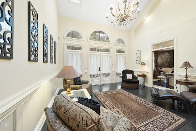 6212 Trevor Ct, Raleigh, NC 27613 - living area featuring high vaulted ceiling, an inviting chandelier, wood finished floors, and a decorative wall
