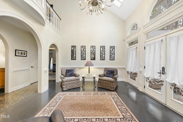 6212 Trevor Ct, Raleigh, NC 27613 - living area featuring high vaulted ceiling, arched walkways, an inviting chandelier, and wood finished floors