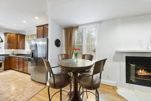 6212 Trevor Ct, Raleigh, NC 27613 - dining room with baseboards, a glass covered fireplace, and recessed lighting