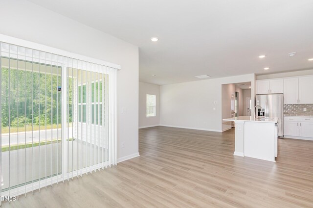 680 Winesap Dr, Graham, NC 27253 - kitchen with tasteful backsplash, white cabinets, baseboards, light countertops, and recessed lighting