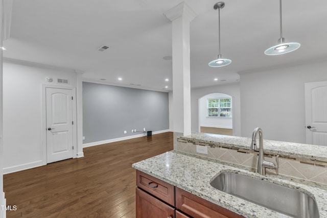 644 Angelica Cir, Cary, NC 27518 - kitchen featuring a sink, dark wood-style flooring, brown cabinetry, open floor plan, and hanging light fixtures