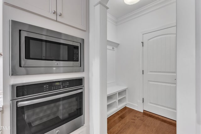 644 Angelica Cir, Cary, NC 27518 - kitchen featuring appliances with stainless steel finishes, crown molding, wood finished floors, and light countertops