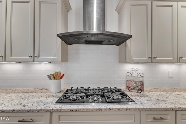 644 Angelica Cir, Cary, NC 27518 - kitchen with ventilation hood, cooktop, tasteful backsplash, and light stone countertops