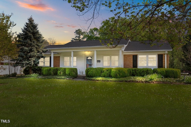 ranch-style house featuring a front lawn, brick siding, and a porch