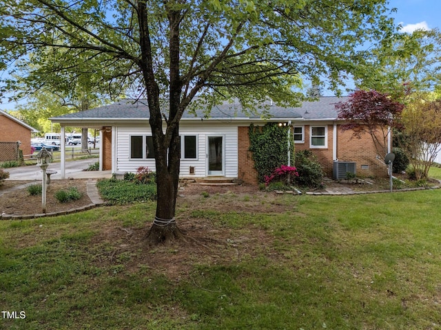 view of front of property with a front lawn, cooling unit, driveway, an attached carport, and brick siding