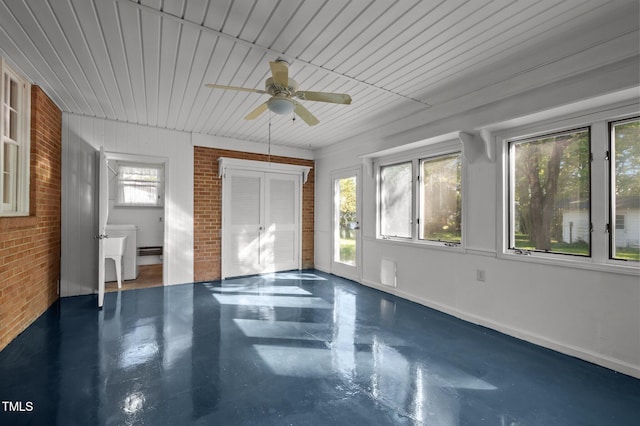 unfurnished bedroom with brick wall, wooden ceiling, ceiling fan, and finished concrete flooring