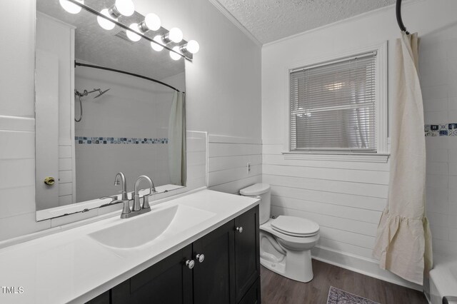 full bath with a textured ceiling, toilet, wood finished floors, crown molding, and vanity