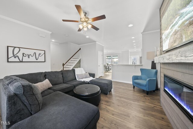 6511 Academic Ave, Raleigh, NC 27616 - living room with crown molding, a glass covered fireplace, wood finished floors, ceiling fan, and stairway