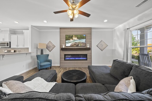 6511 Academic Ave, Raleigh, NC 27616 - living room featuring wood finished floors, visible vents, ornamental molding, baseboards, and ceiling fan