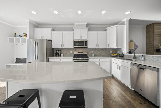6511 Academic Ave, Raleigh, NC 27616 - kitchen featuring white cabinets, ornamental molding, a sink, decorative backsplash, and appliances with stainless steel finishes