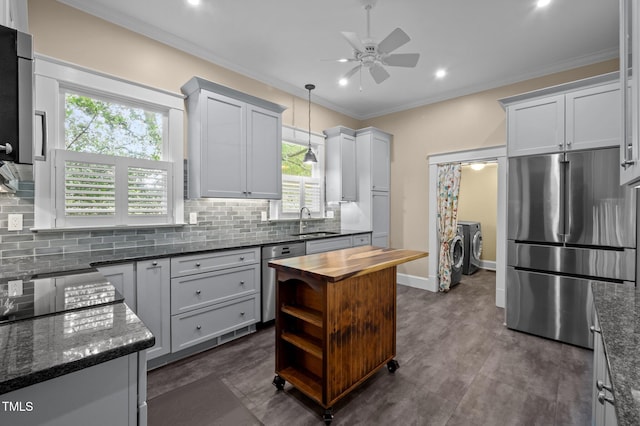109 N Hassel St, Hillsborough, NC 27278 - kitchen with appliances with stainless steel finishes, washer and clothes dryer, ceiling fan, backsplash, and ornamental molding