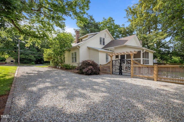 109 N Hassel St, Hillsborough, NC 27278 - view of side of home featuring a chimney, a sunroom, a shingled roof, and gravel driveway