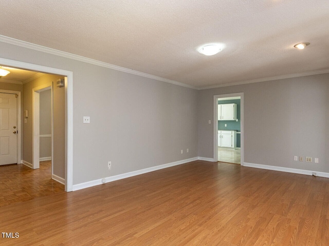 unfurnished room featuring light wood-type flooring, ornamental molding, and baseboards