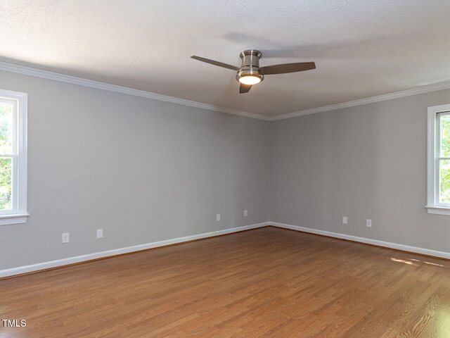 empty room featuring crown molding, a ceiling fan, baseboards, and wood finished floors