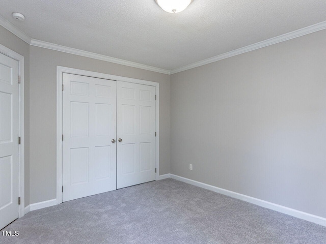 unfurnished bedroom featuring crown molding, carpet, and a closet