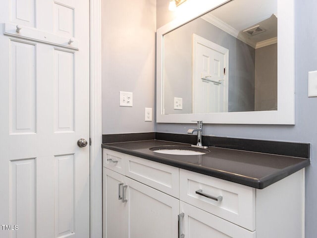 bathroom featuring vanity, ornamental molding, and visible vents