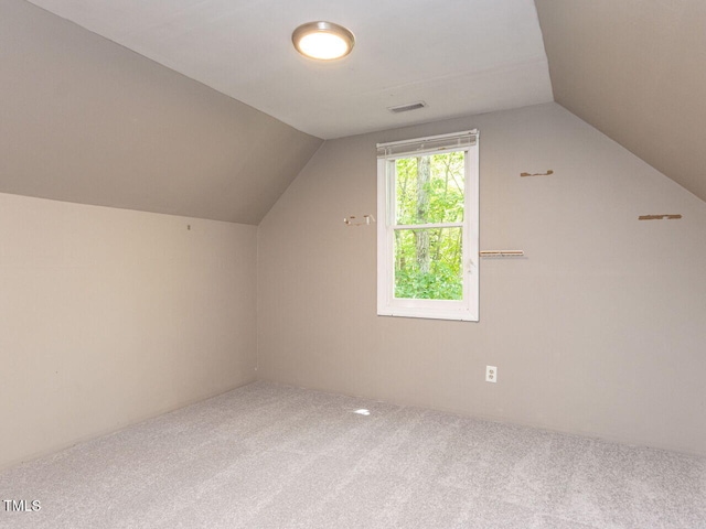 additional living space featuring visible vents, vaulted ceiling, and carpet
