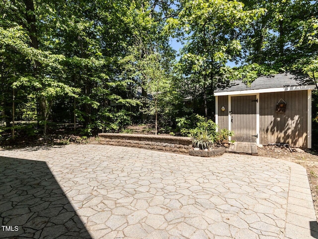 view of patio / terrace with an outdoor structure and a shed