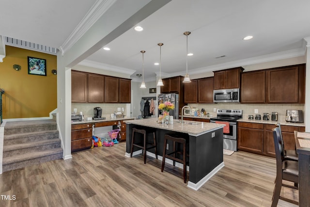 kitchen with a kitchen breakfast bar, crown molding, light wood-type flooring, stainless steel appliances, and backsplash