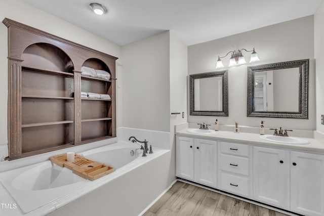 1311 Theodore Ln, Durham, NC 27703 - bathroom featuring double vanity, a garden tub, and wood finished floors