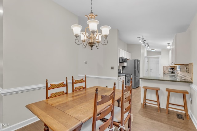 1311 Theodore Ln, Durham, NC 27703 - dining space with light wood-type flooring and a chandelier