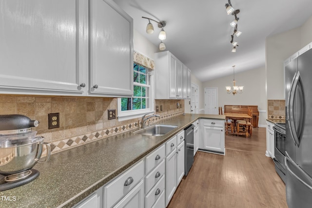 1311 Theodore Ln, Durham, NC 27703 - kitchen with a sink, appliances with stainless steel finishes, a chandelier, white cabinets, and vaulted ceiling