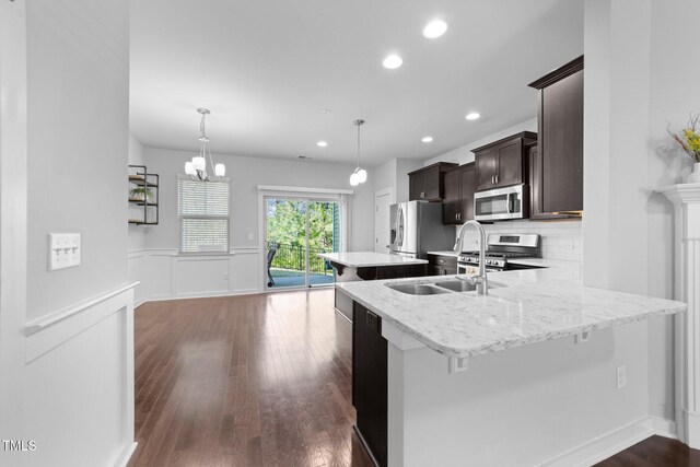 6230 Pesta Ct, Raleigh, NC 27612 - kitchen featuring appliances with stainless steel finishes, a sink, dark brown cabinets, dark wood finished floors, and recessed lighting