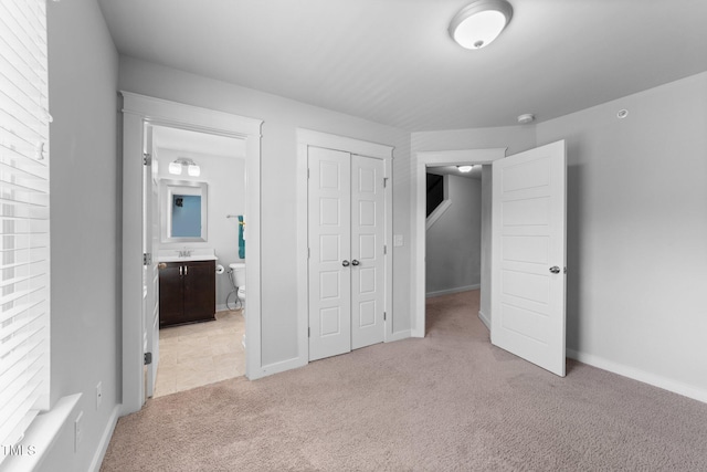 6230 Pesta Ct, Raleigh, NC 27612 - unfurnished bedroom with light colored carpet, a closet, ensuite bathroom, and baseboards