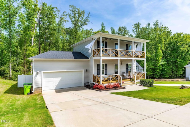 view of front of home featuring covered porch, a garage, driveway, a balcony, and a front yard