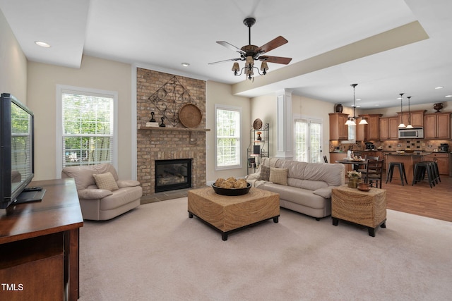 living area featuring recessed lighting, a brick fireplace, light colored carpet, and ceiling fan